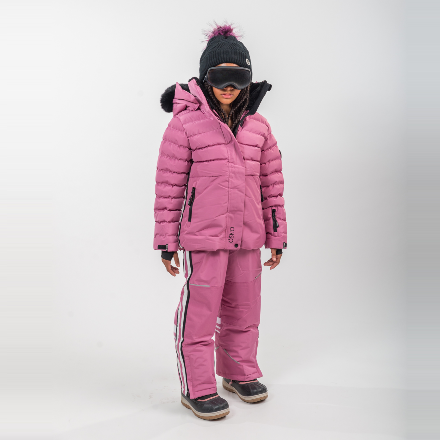 Person wearing a pink winter coat and pants on a white background
