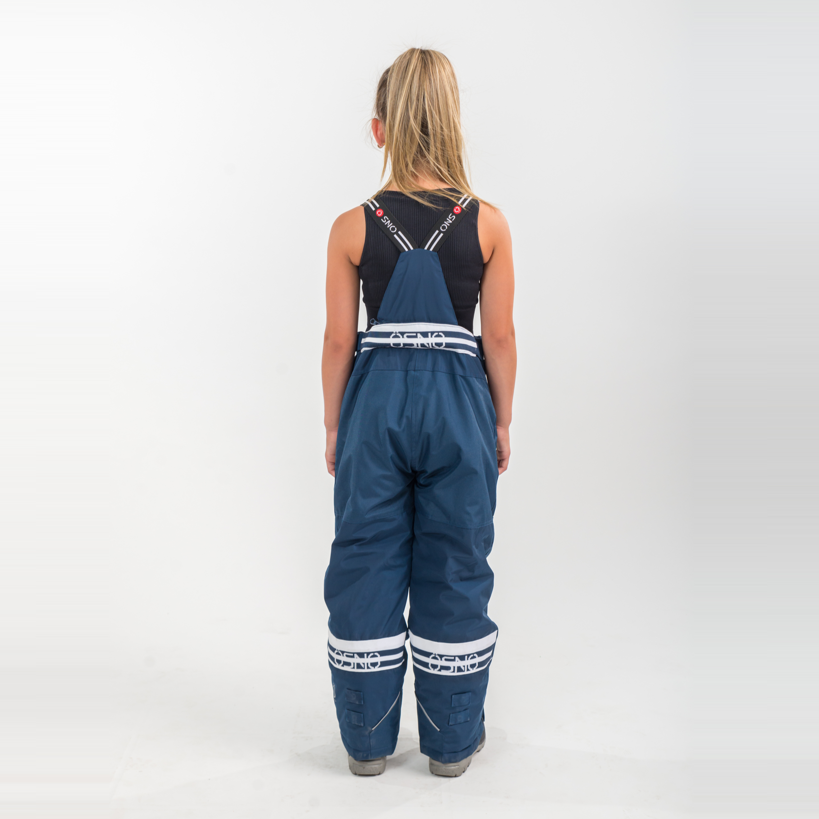 Person wearing blue overalls with white stripes on a white background