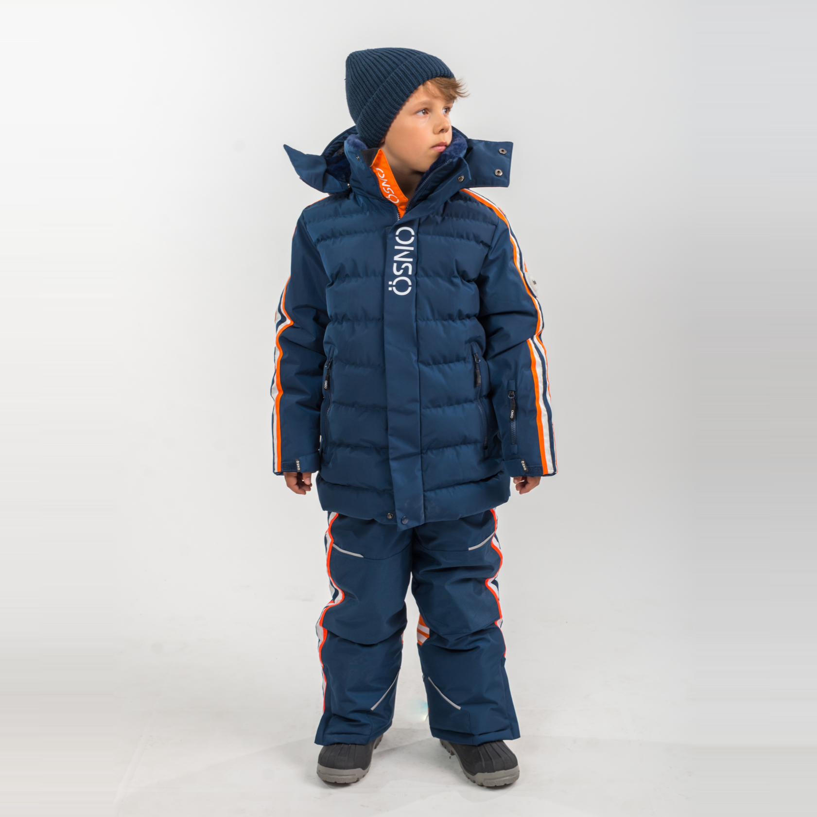 Child wearing a blue winter suit with orange accents on a white background