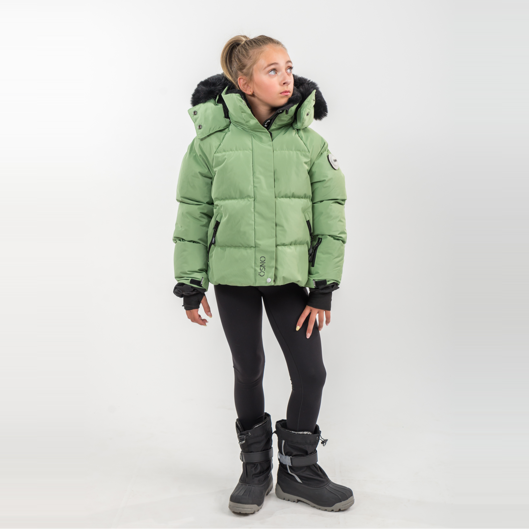 Person wearing a green puffer jacket on a white background