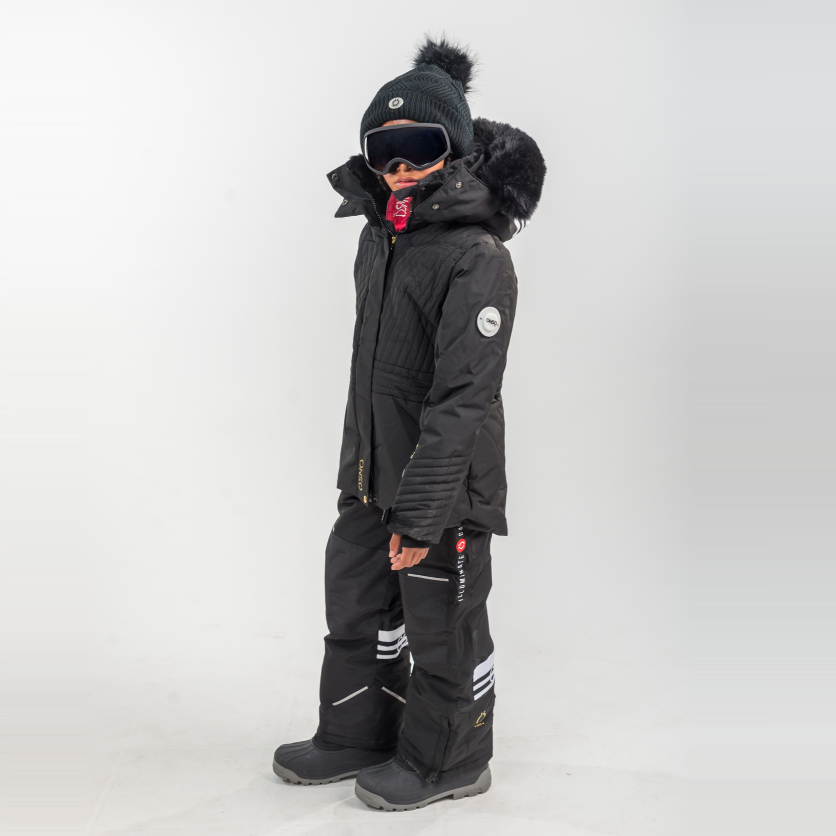 Person wearing a black winter coat and pants on a white background