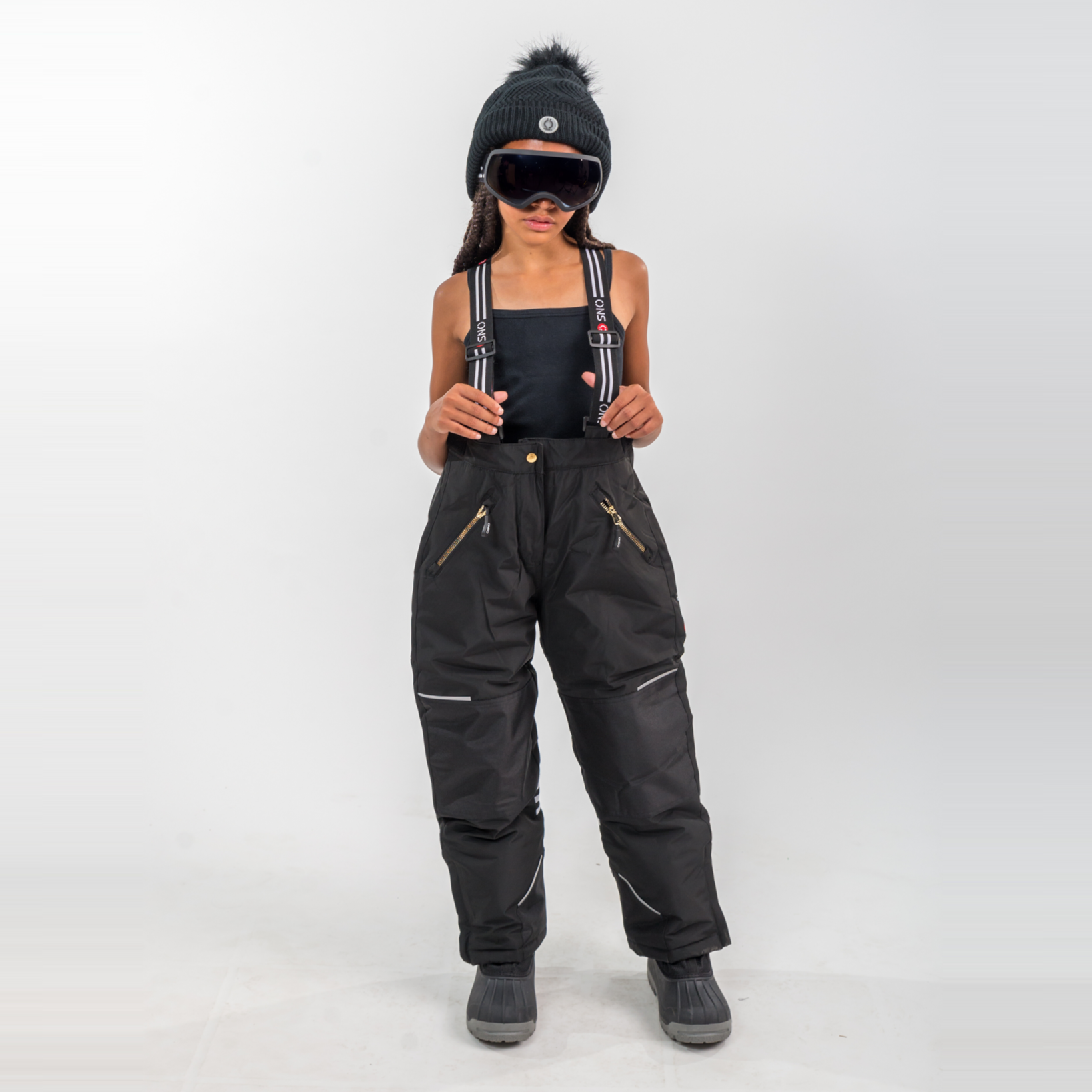 Person wearing black snow pants and goggles on a white background