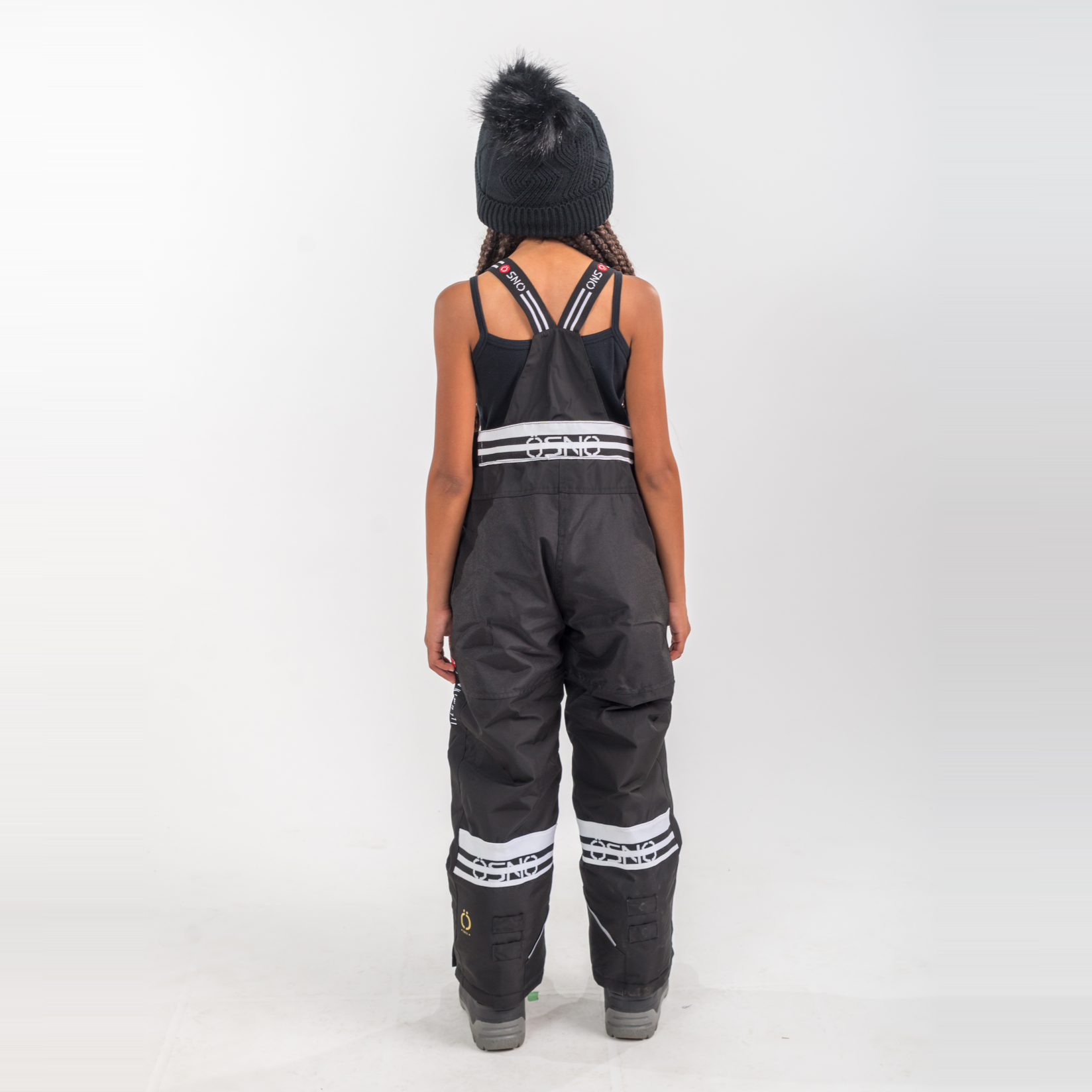Person wearing black overalls with reflective stripes on a white background