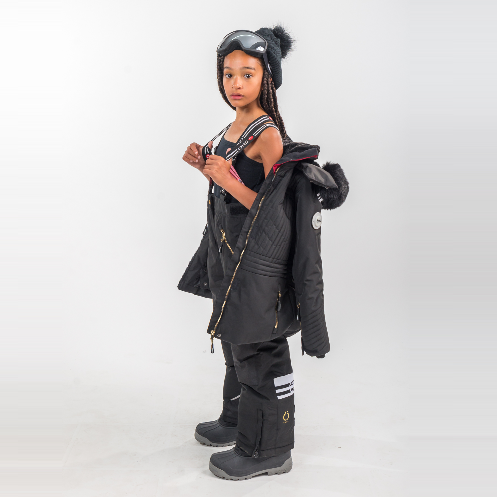 Person wearing a black snowsuit with goggles on a white background