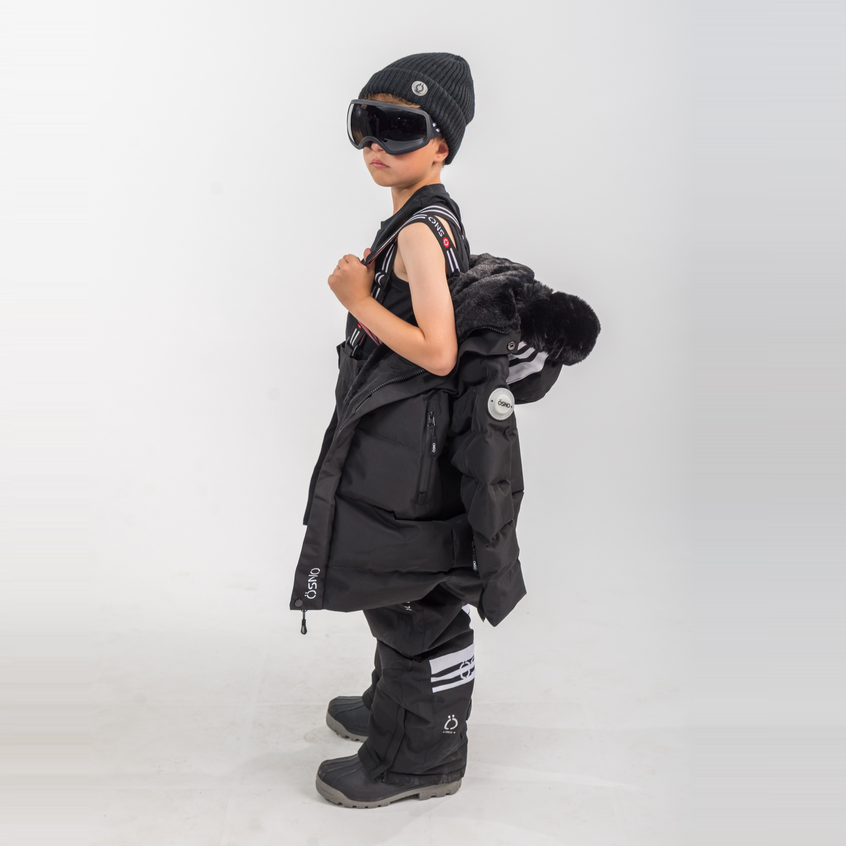 Person wearing a black outfit with a backpack on a white background