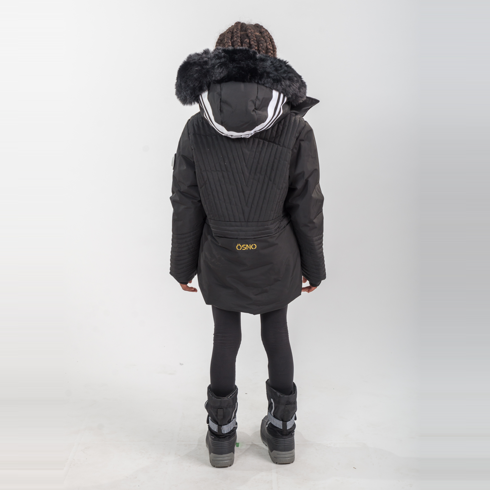 Person wearing a dark gray winter coat with fur-lined hood on a white background