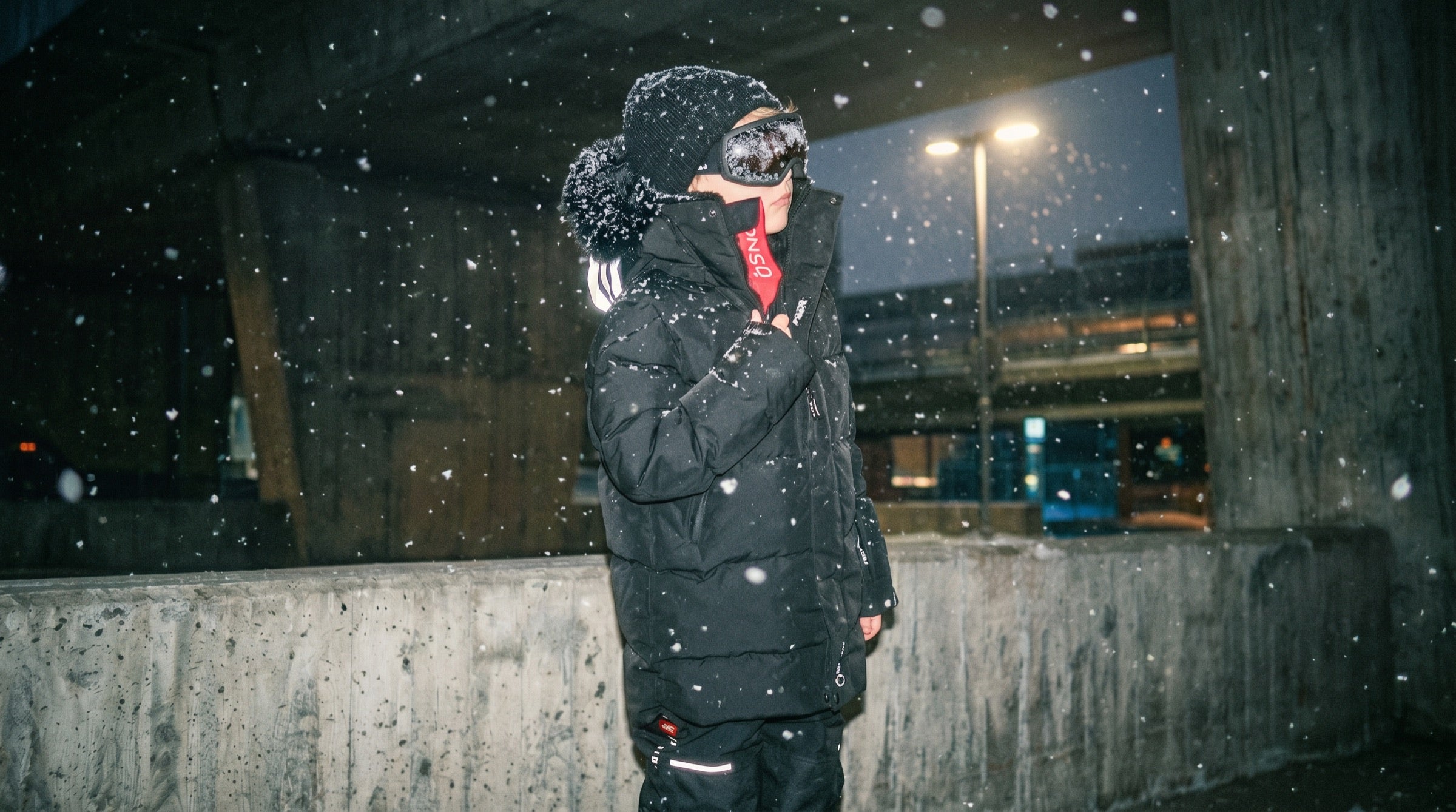 Kid wearing an ÖSNO snowsuit at night in the snow
